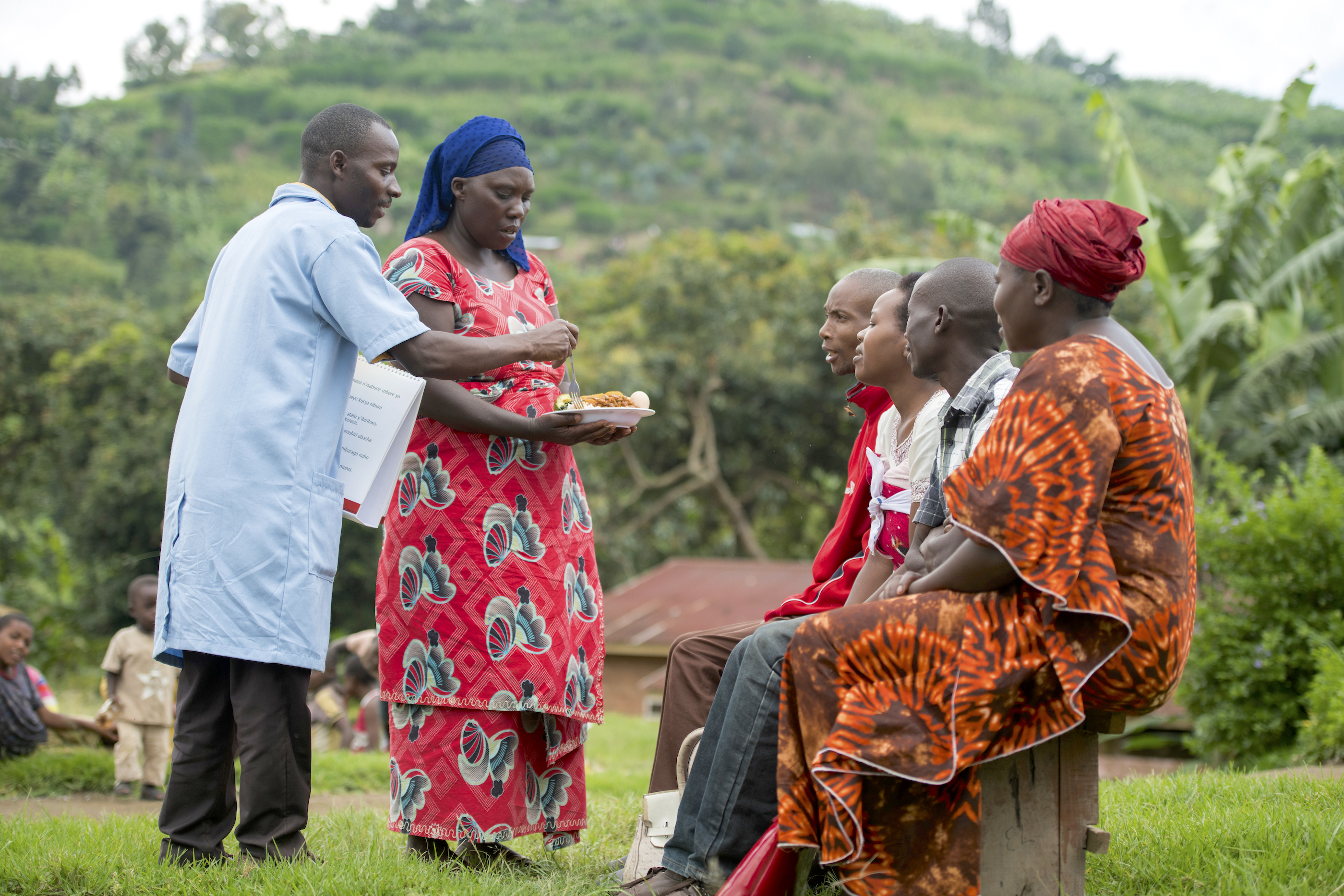 A community health worker in Rwanda talks to people on hygiene and the importance of a balanced diet, as part of the SUSTAIN project. (Photo: CIP)