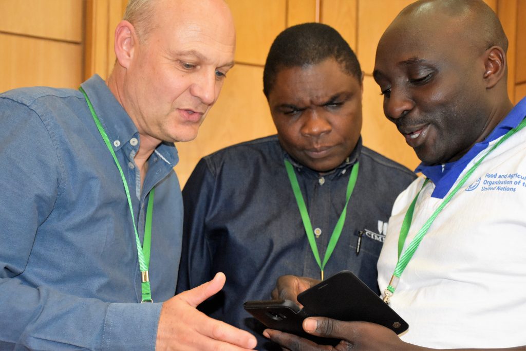 CIMMYT researchers Dave Hodson (left) and Francis Mwatuni (center) discuss MLN issues with another delegate during the 3-year MLN project review workshop. (Photo: Joshua Masinde/CIMMYT)