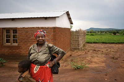 Belita Maleko, a farmer in rural Malawi, stands in front of her house. Photo: T. Samson/CIMMYT.