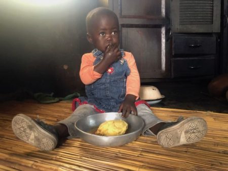 Ashley Muzhange, 18 months old, eats sadza porridge in the Chiweshe Communal Area. This porridge is made of vitamin A orange maize, a variety improving the nutrition of children and families in Zimbabwe.