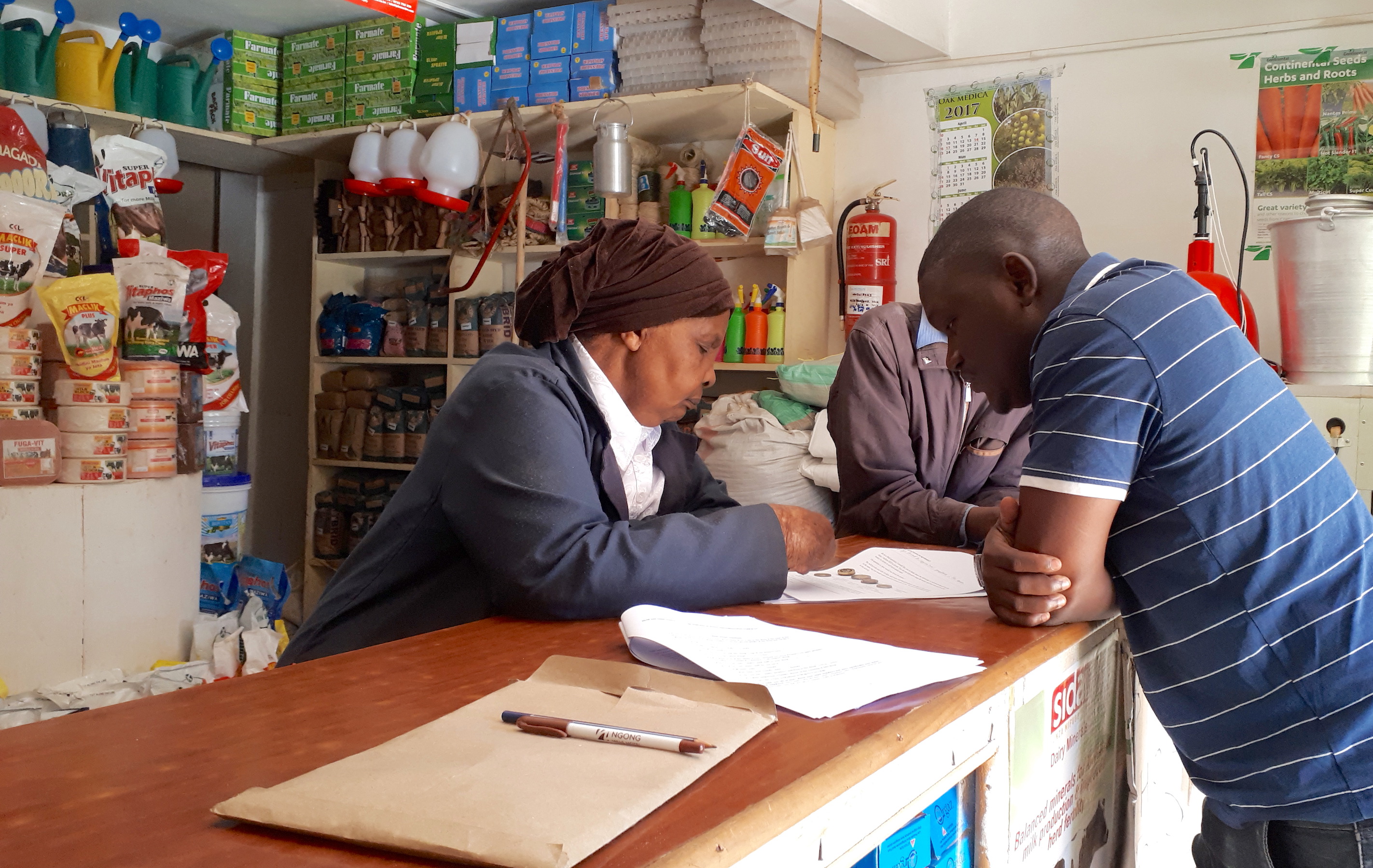 The 70-year-old owner of a farm input shop in Kikuyu town, Kiambu County, answers the questions of CIMMYT researchers. (Photo: Jerome Bossuet/CIMMYT)