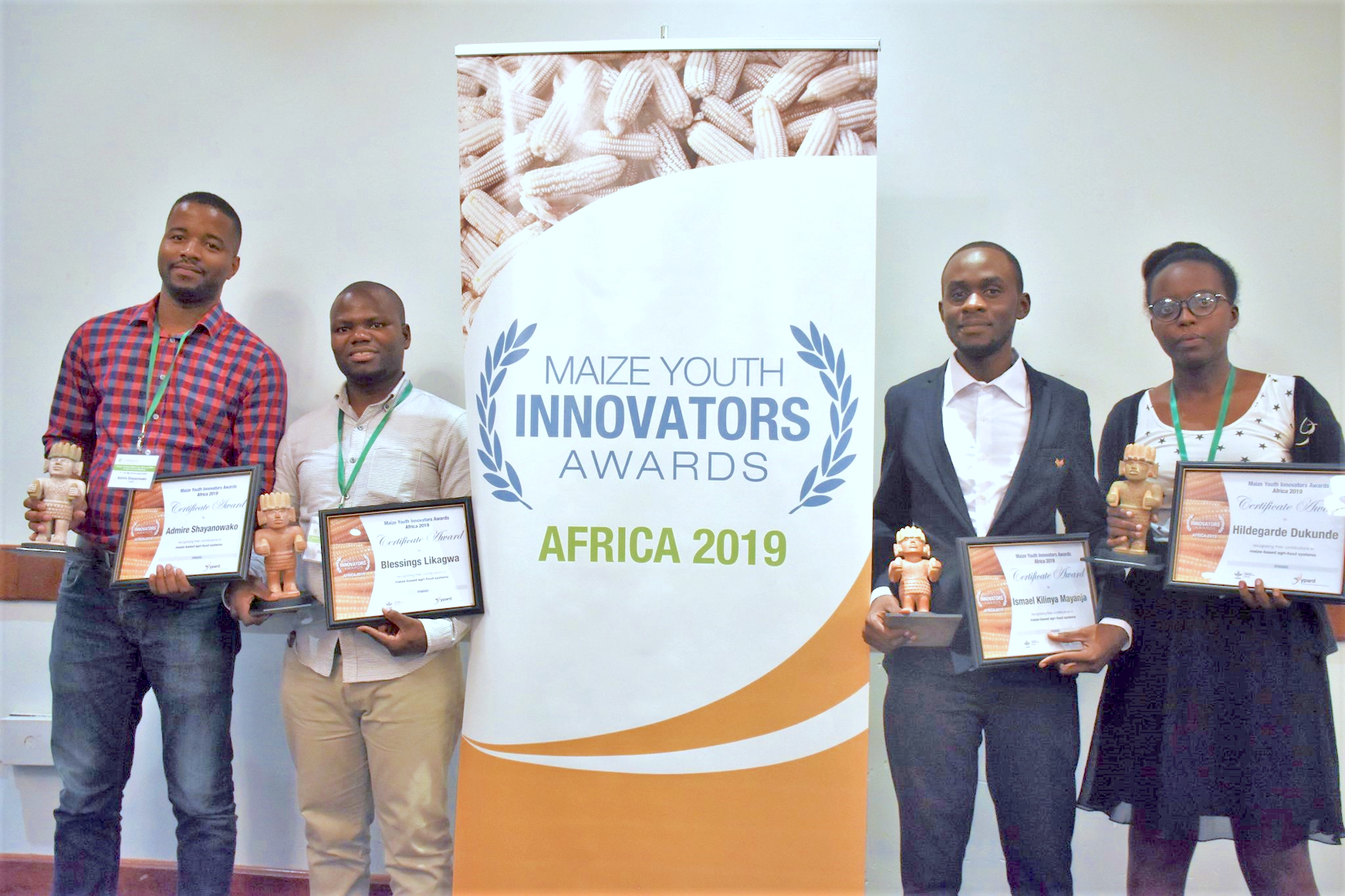 Winners of the 2019 MAIZE Youth Innovators Awards – Africa receive their awards at the STMA meeting in Lusaka, Zambia. From left to right: Admire Shayanowako, Blessings Likagwa, Ismael Mayanja and Hildegarde Dukunde. Fifth awardee Mila Lokwa Giresse not pictured. (Photo: J.Bossuet/CIMMYT)