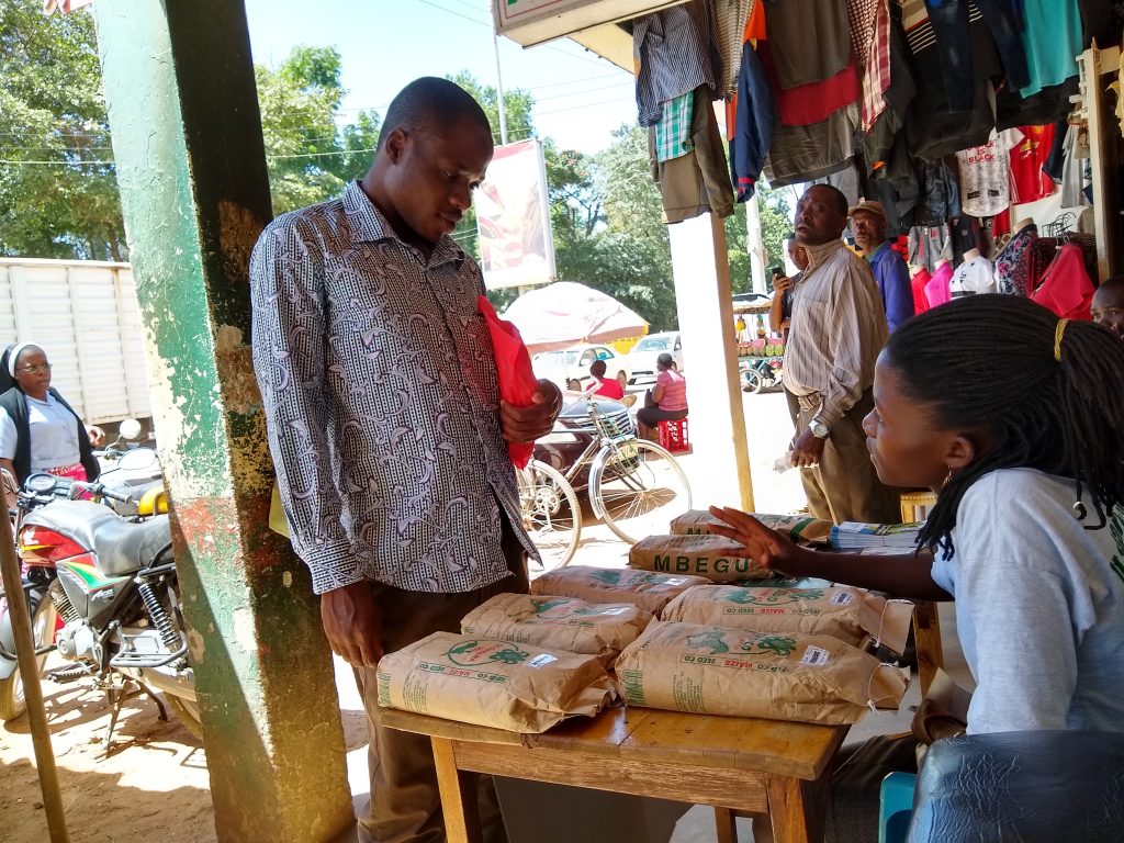 An agent from a seed company (right) promotes sales at an agro-dealer shop. (Photo: Pieter Rutsaert/CIMMYT)