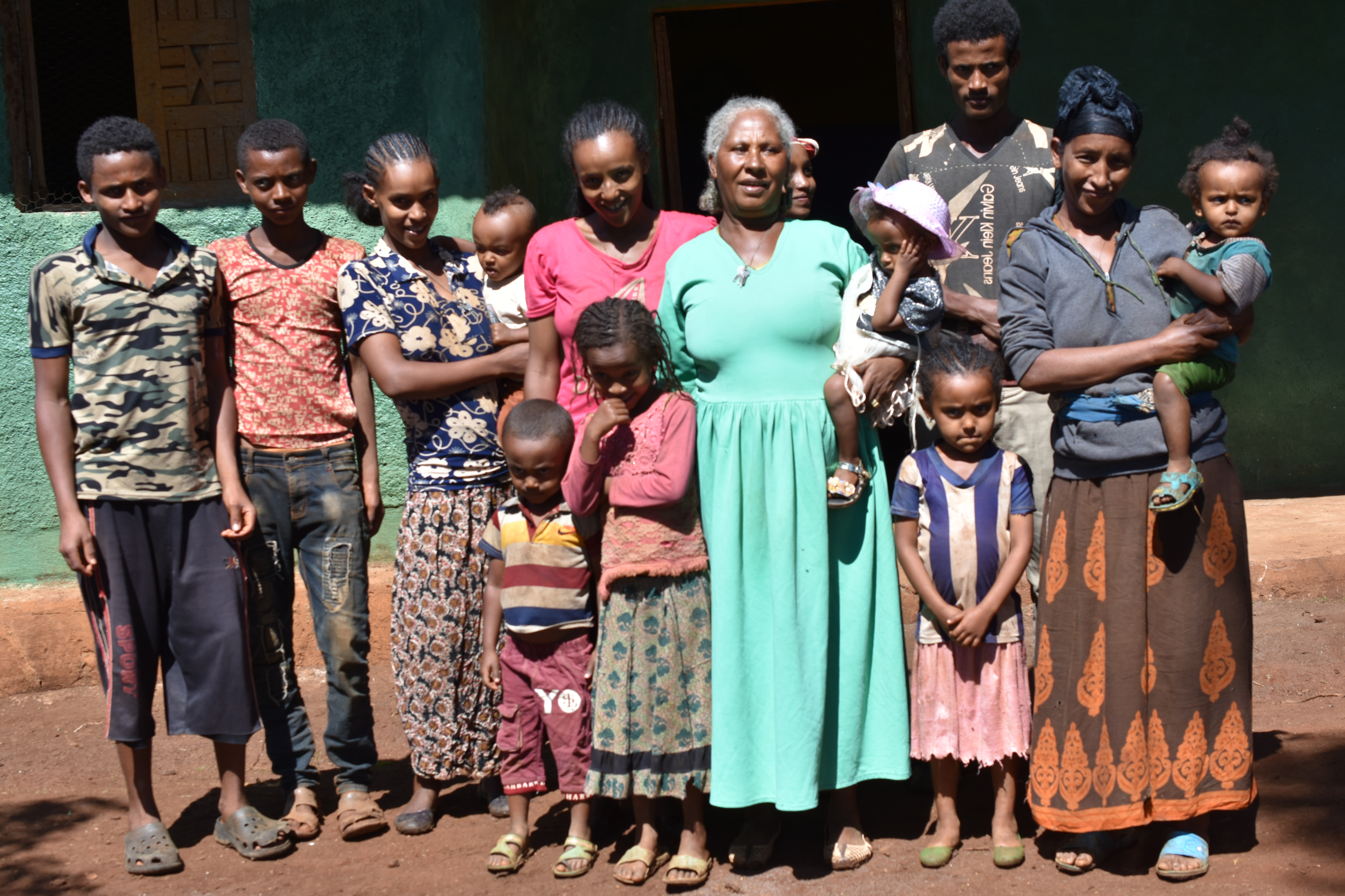 Sequare Regassa (wearing green) and her family stand for a group photo at their farm. (Photo: Simret Yasabu/CIMMYT)