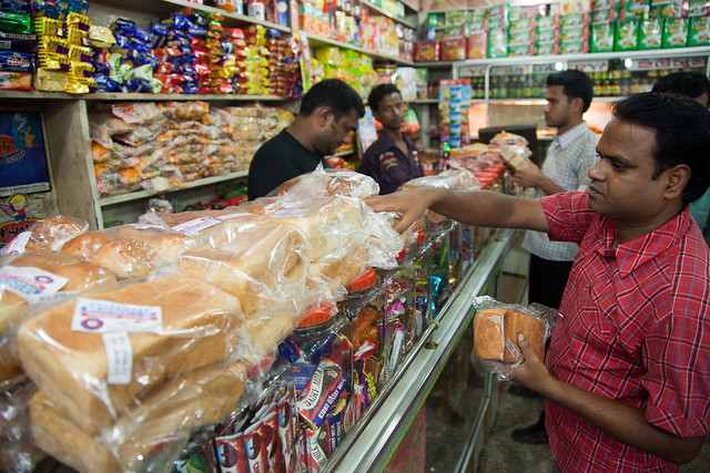 A customer chooses bread in a small shop in Dinajpur, Bangladesh. (Photo: S. Mojumder/Drik/CIMMYT)