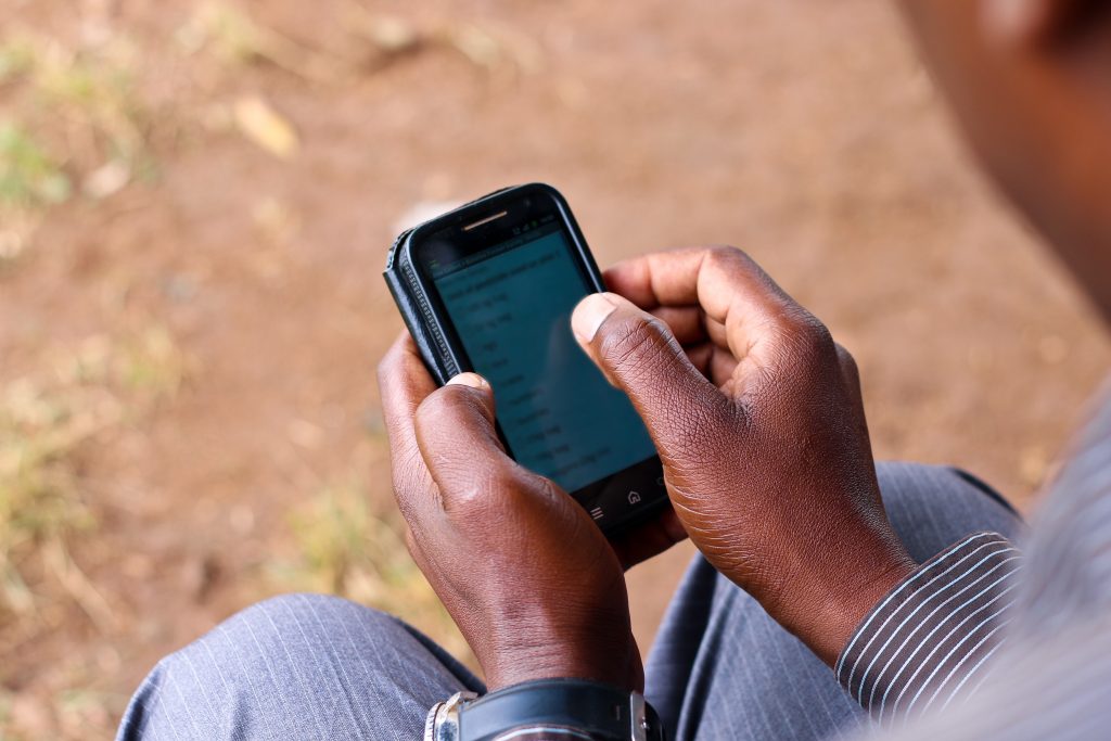 A farmer uses a smartphone to access market information.