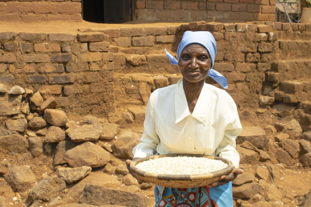 Rose Aufi shows some of her maize grain reserves. (Photo: Shiela Chikulo/CIMMYT)