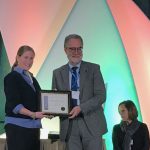 Hans-Joachim Braun (center) receives the Crop Science Society of America Fellow certificate onstage. (Photo: Johanna Franziska Braun/CIMMYT)