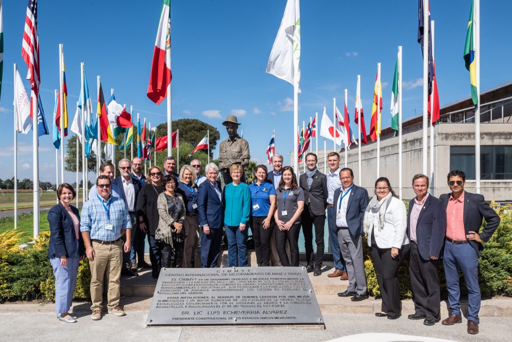 The US delegation stands for a group photo next to the sculpture of Norman Borlaug at the global headquarters of CIMMYT. (Photo: Eleusis Llanderal/CIMMYT)