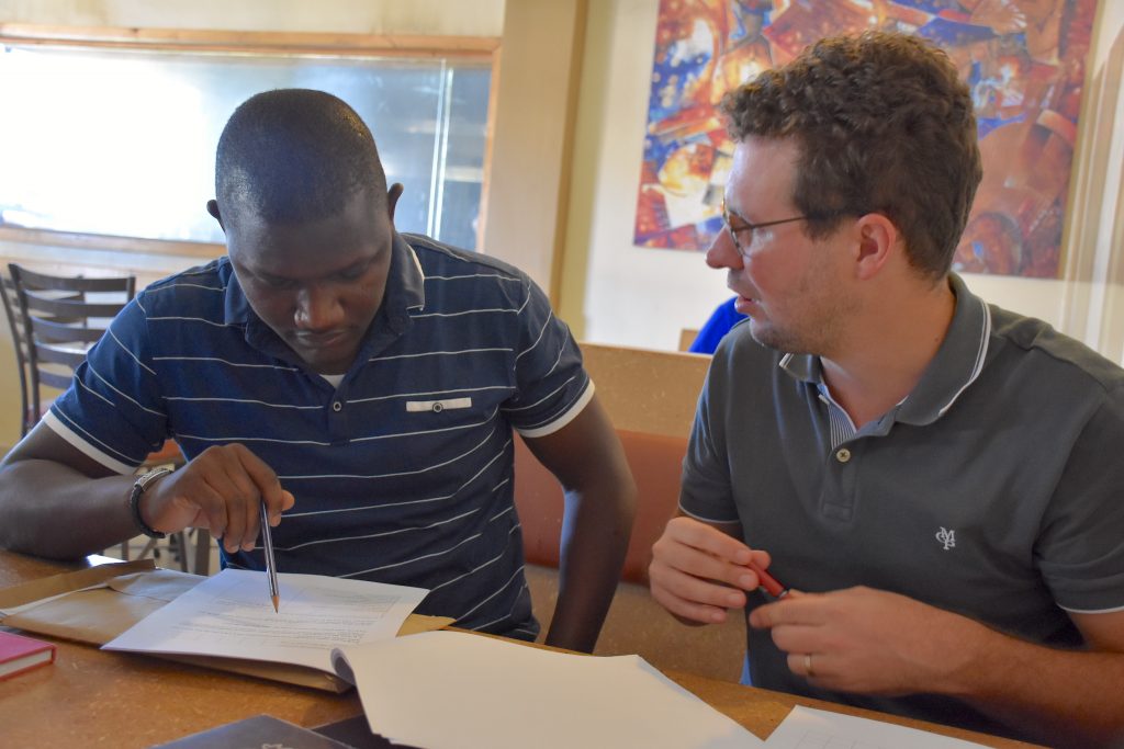 Pieter Rutsaert (right) discusses a research study questionnaire with consultant enumerator Victor Kitoto. (Photo: Jerome Bossuet/CIMMYT)