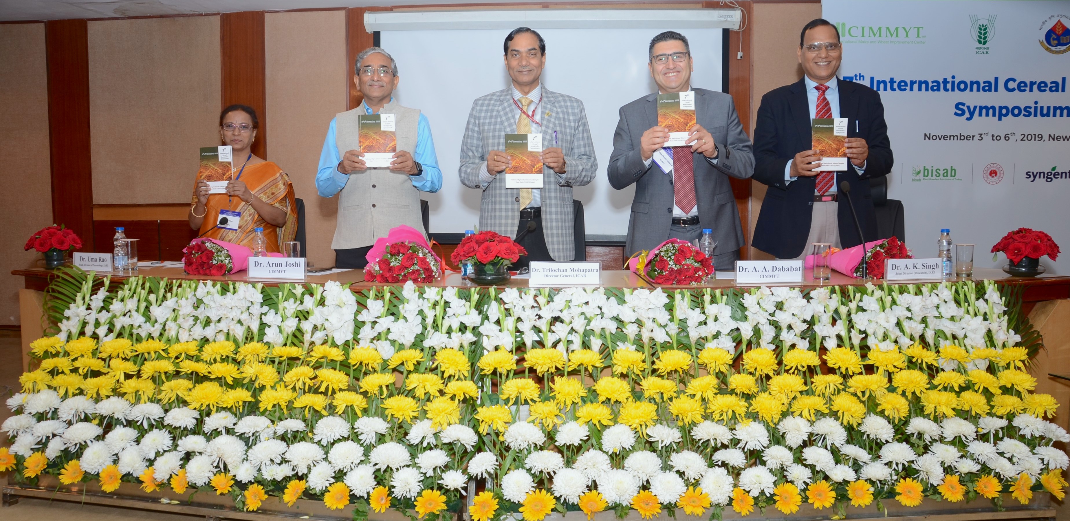 Organizers hold copies of the abstract book, released during the symposium.