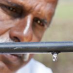 A farmer checks the drip irrigation system at his rice field in India. (Photo: Hamish John Appleby/IWMI)