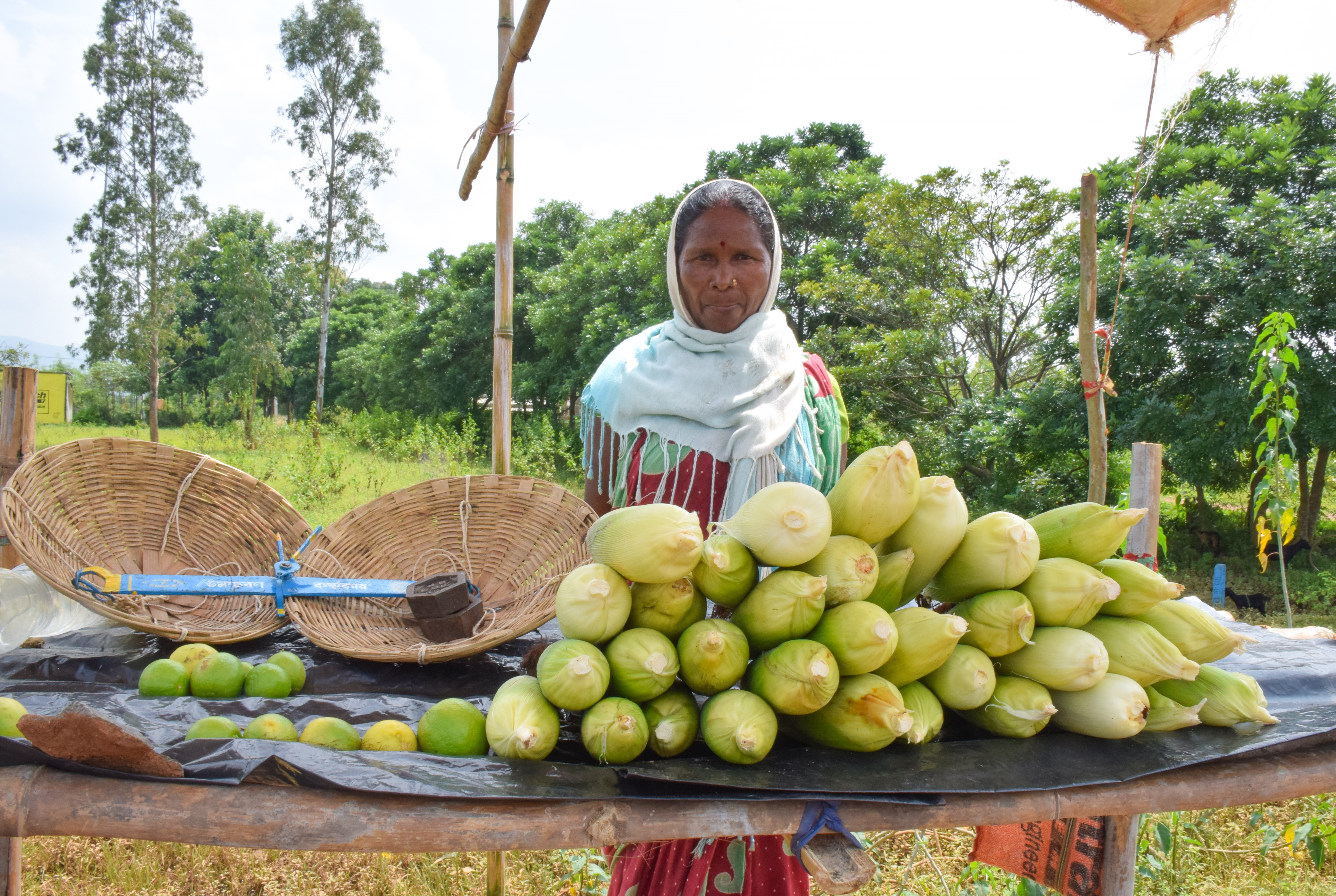 Women shows off maize stall.