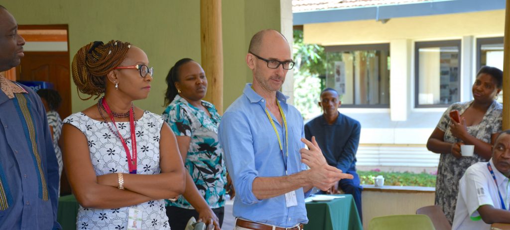 Jordan Chamberlin (center) talks to colleagues during a staff gathering in Nairobi. (Photo. Joshua Masinde/CIMMYT)