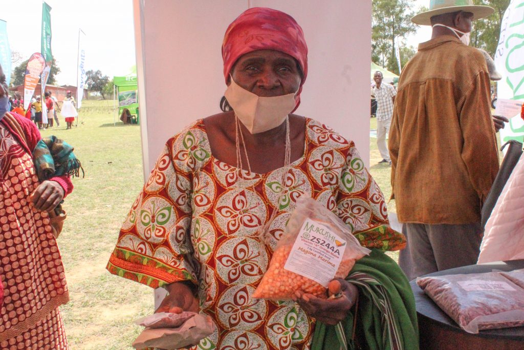 A customer shows off her orange maize purchases at a seed fair in Masvingo, Zimbabwe. (Photo: S. Chikulo/CIMMYT)