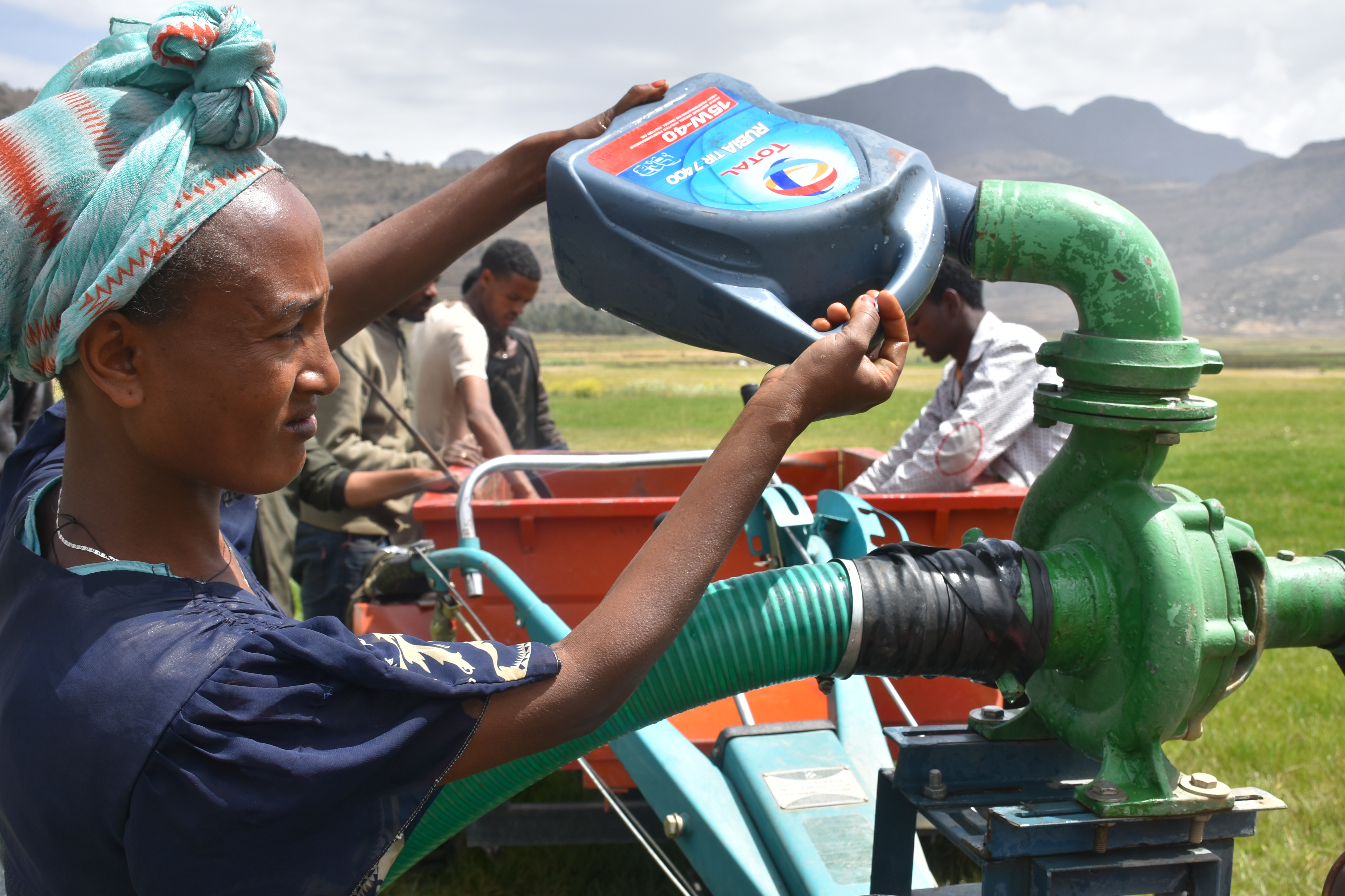 A member of an agricultural mechanization youth association in Ethiopia’s Tigray region fills a two-wheel tractor with water before irrigation. (Photo: Simret Yasabu/CIMMYT)