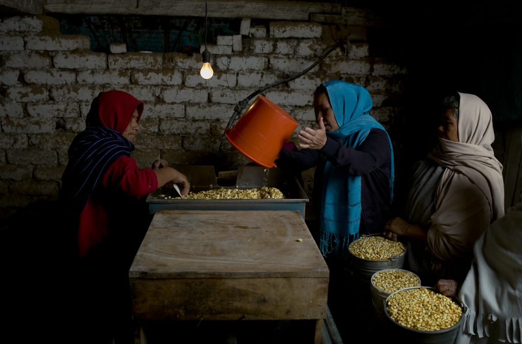 Women mill nixtamalized maize in Michoacan, Mexico. (Photo: Peter Lowe/CIMMYT)