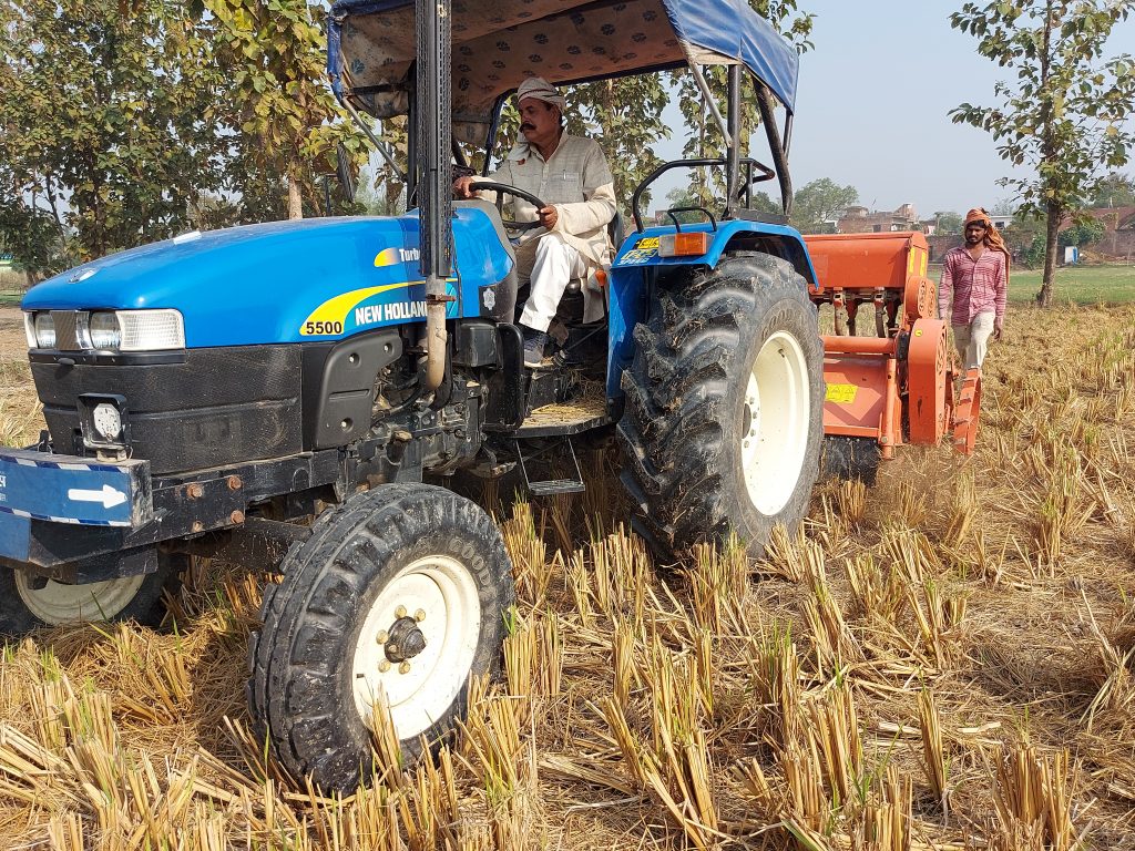 Surender Prasad drives his Happy Seeder-mounted tractor in Uttar Pradesh, India. (Photo: Nima Chodon/CIMMYT)