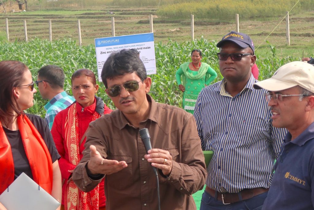 Dyutiman Choudhary shows a demonstration plot during a field visit with USAID and project partners in Nepal. (Photo: Darbin Joshi)