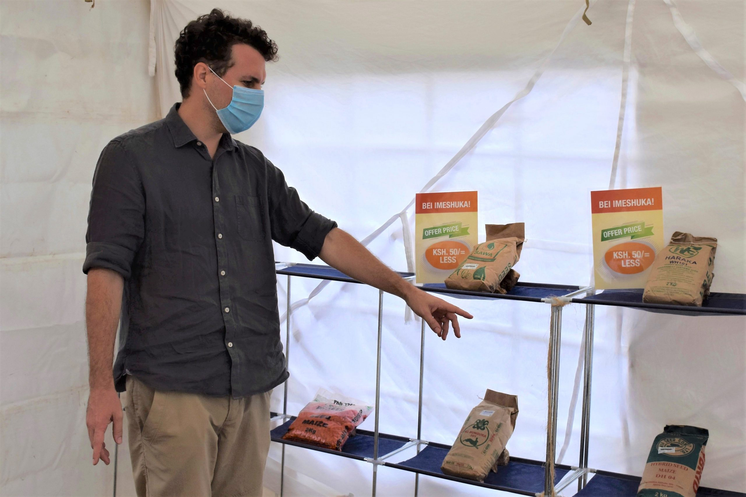 Pieter Rutsaert explains the study setup at a mock agrodealer shop. (Photo: Joshua Masinde/CIMMYT)