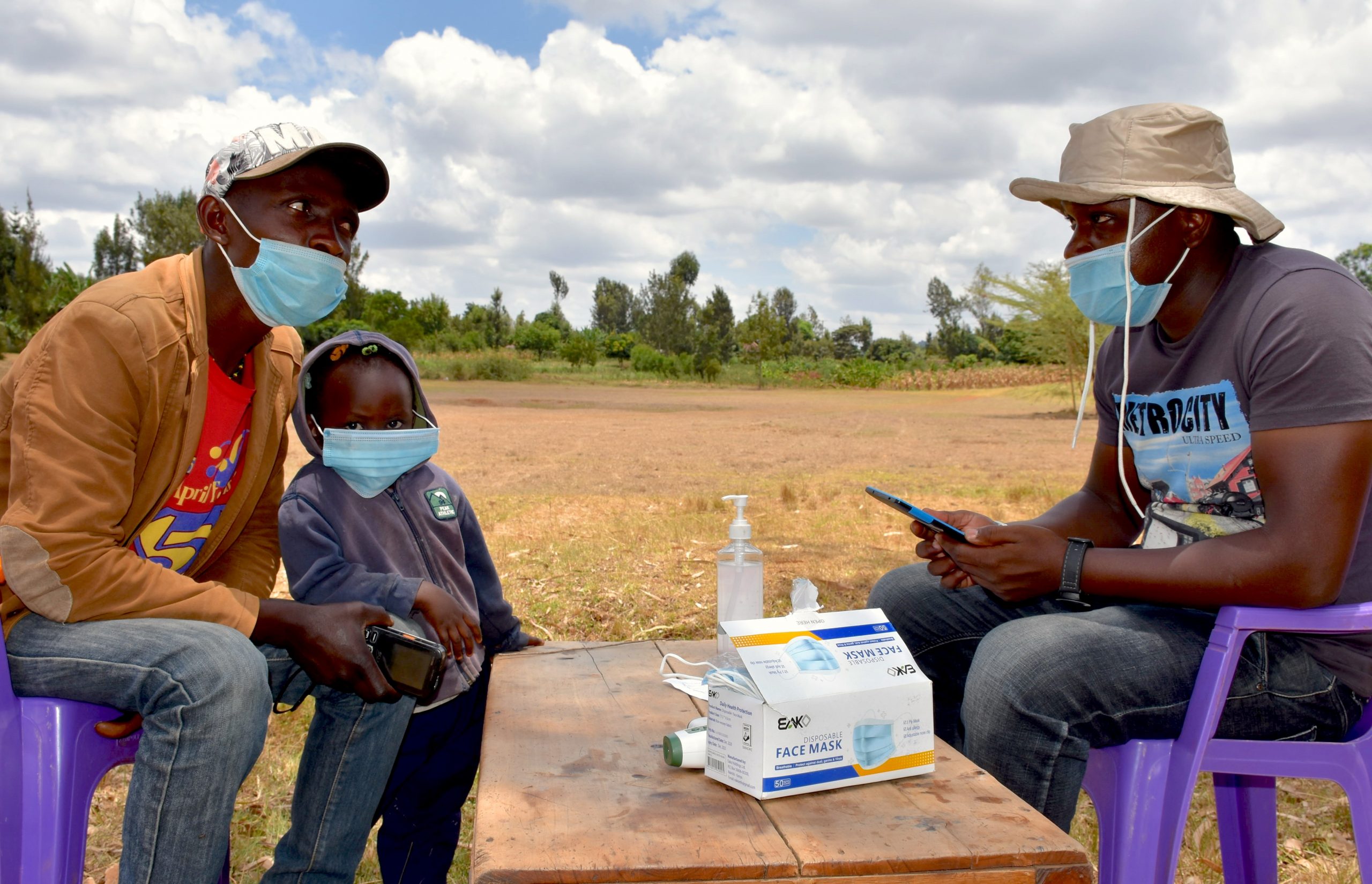 Michael Mutua (left) responds to preliminary questions from one of the research team members before proceeding to make his seed selection at the mock agrodealer shop. (Photo: Joshua Masinde/CIMMYT)