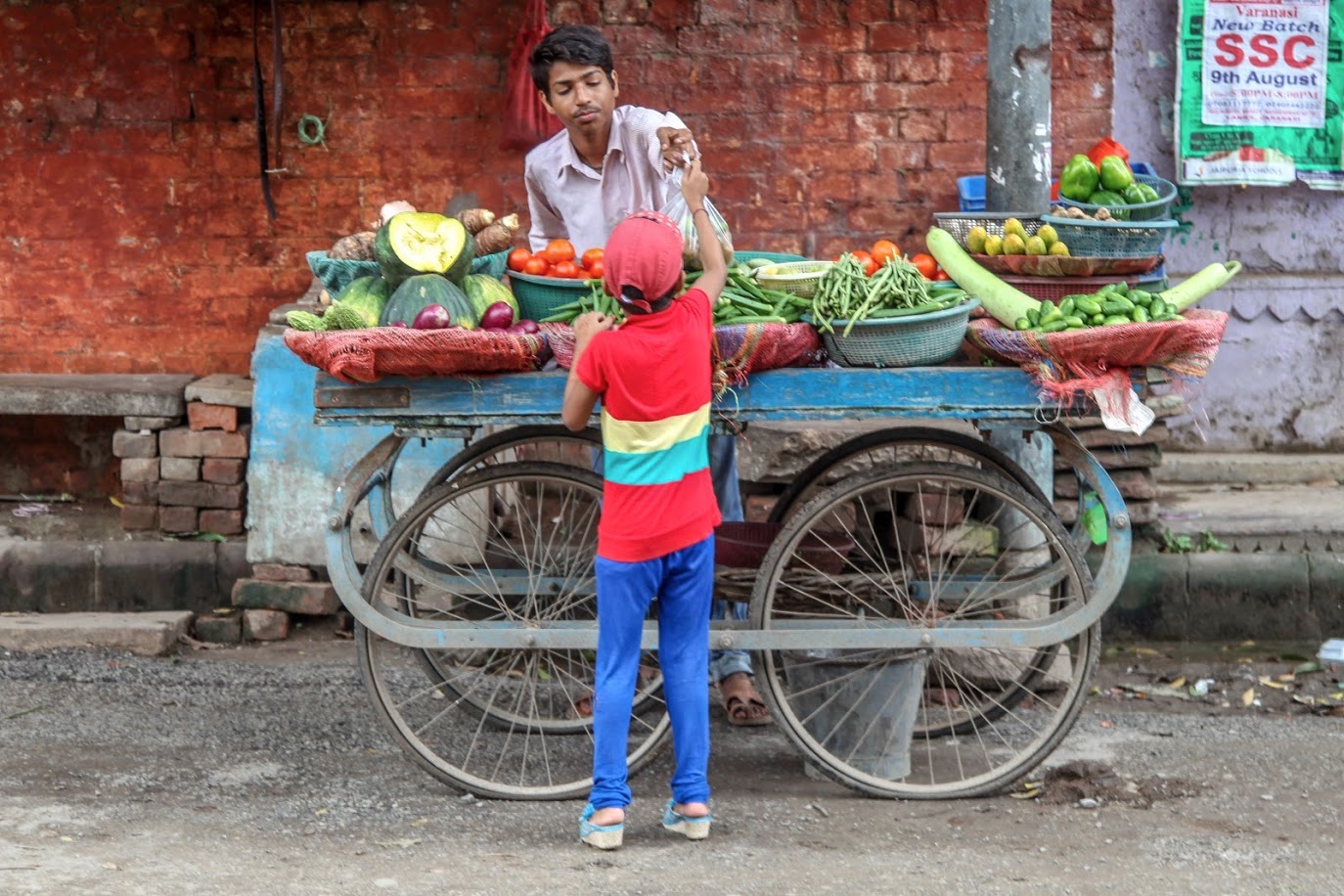 A child buys fruits and vegetables from a street cart in Varanasi, India. (Photo: Gert-Jan Stads/International Food Policy Research Institute)