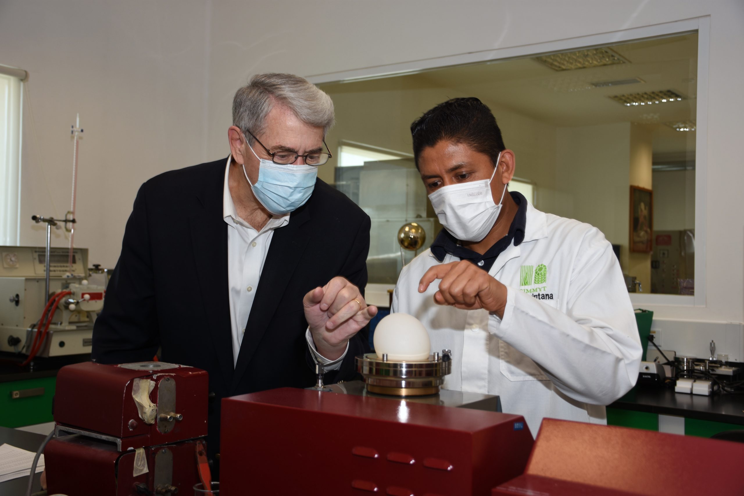 Ted McKinney (left) listens to a technician explaining the use of an alvograph. (Photo: Francisco Alarcón/CIMMYT)
