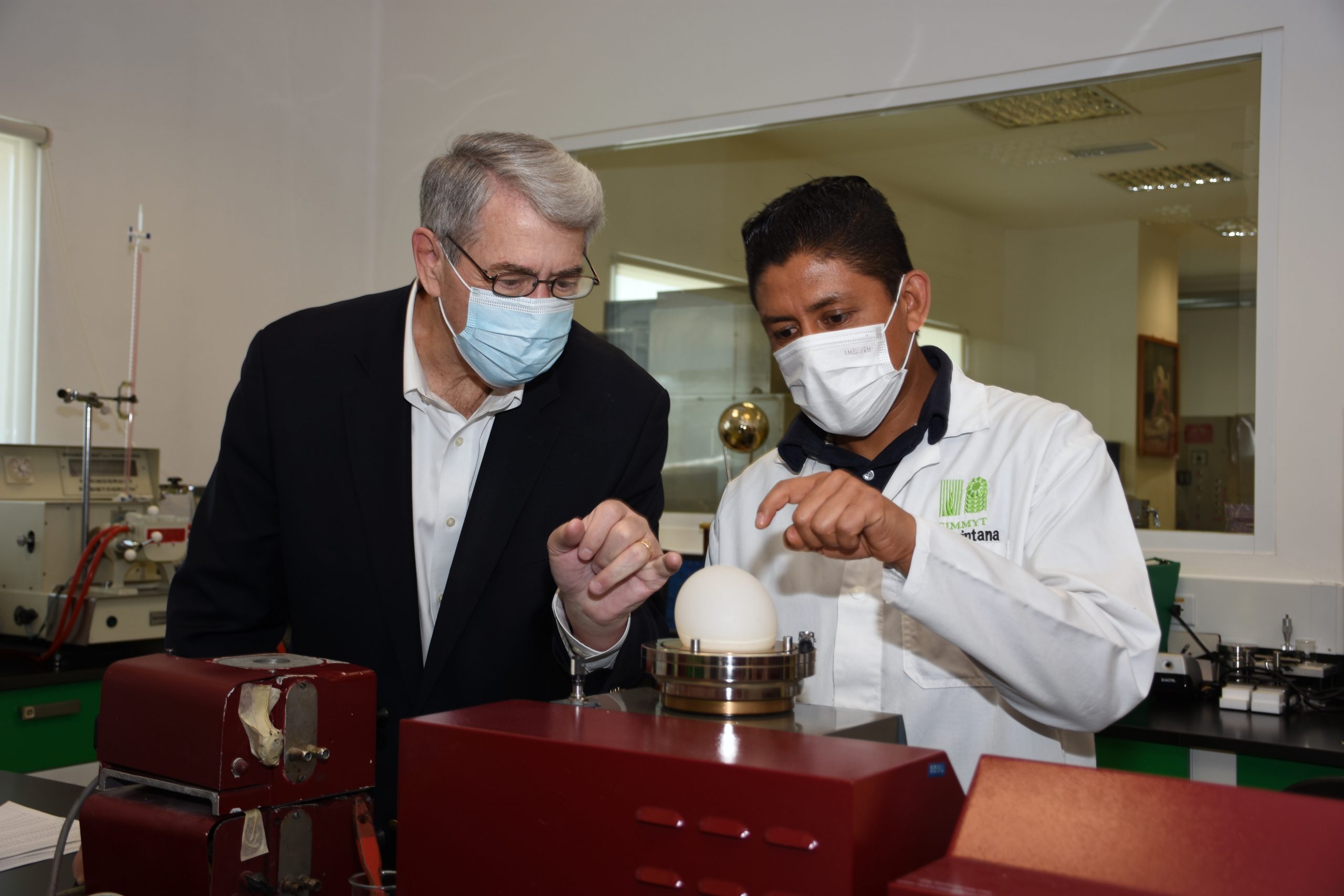 Ted McKinney (izquierda) escucha a un técnico que le explica el uso de un alvógrafo. (Foto: Francisco Alarcón/CIMMYT)