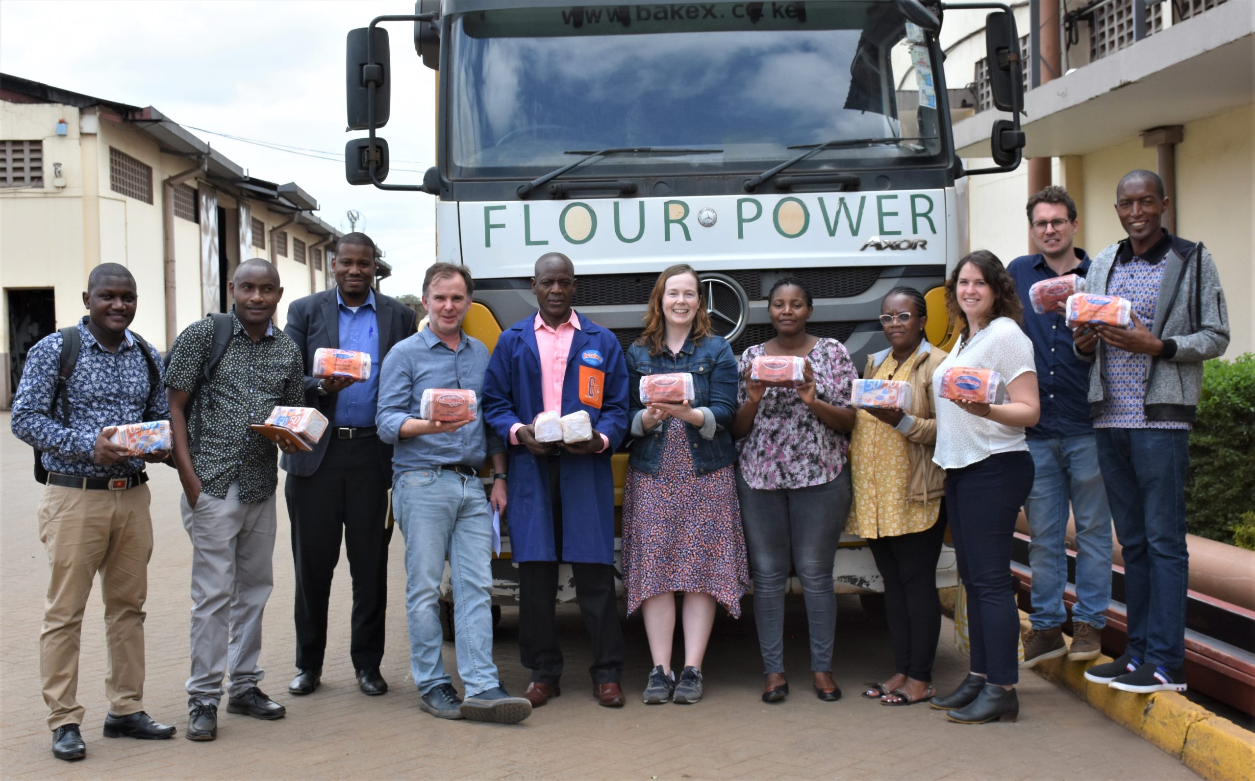 CIMMYT researchers and staff from the East Africa Grain Council hold loaves of bread at a bakery on the outskirts of Nairobi, Kenya. (Photo: Susan Otieno/CIMMYT)