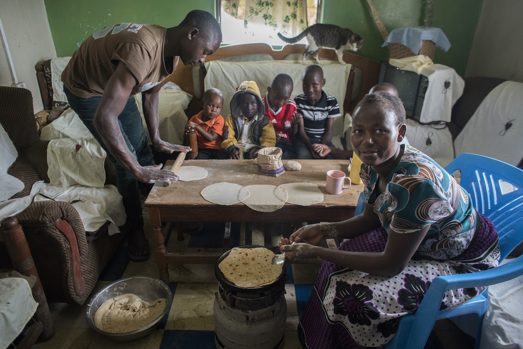 La agricultora Gladys Kurgat prepara chapatti de trigo con ayuda de su sobrino Emmanuel Kirui para sus cinco hijos en su casa cerca de Belbur, Nakuru, Kenia. (Foto: Peter Lowe/CIMMYT)