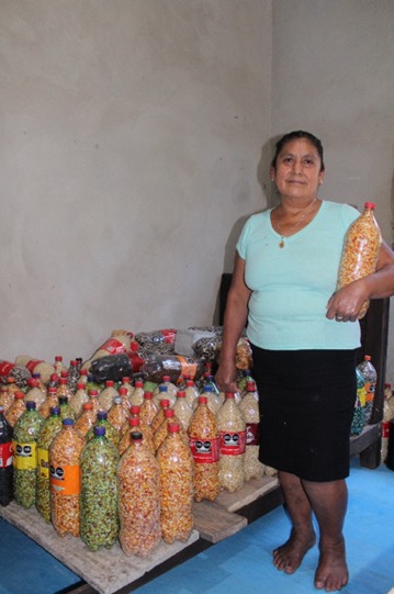 La señora Crecencia Parcero mostrando el uso de los envases PET para el almacenamiento de grano, en el ejido San Martín Chamizal, Palenque, Chiapas. 5 febrero 2024. (Foto: Benancio Jiménez Gómez)