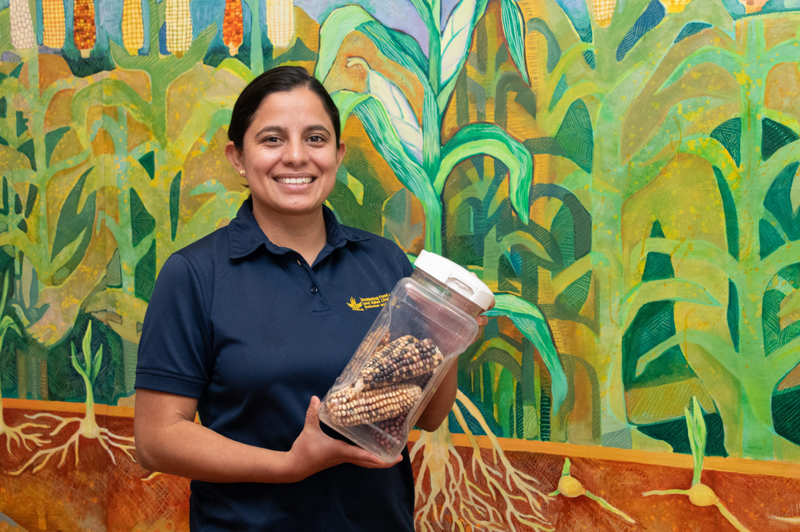 Meliza Peña muestra un ejemplo de almacenamiento seguro: envases herméticos que protegen las semillas del aire, la humedad y la luz, facilitando su conservación para próximos ciclos. (Foto: Jenifer Morales/CIMMYT)