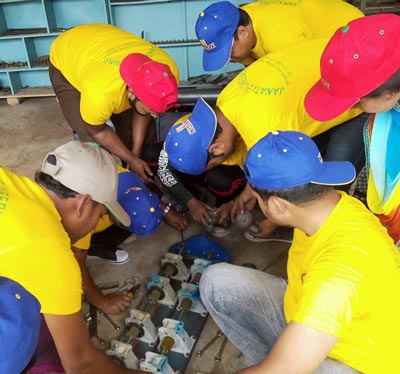 Participants working on a machine part.