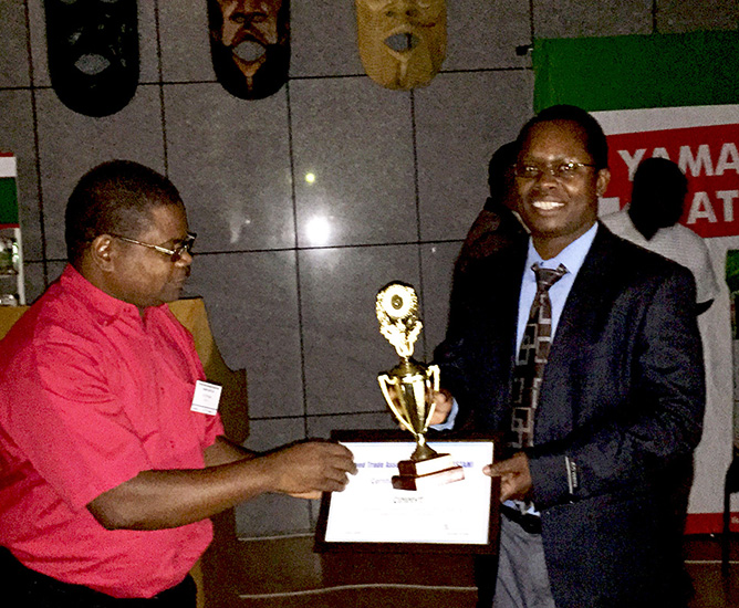 Kennedy Lweya, Seed Business Development Specialist for East and Southern Africa, receives an award on behalf of CIMMYT during the Seed Trade Association of Malawi Congress and Expo. Photo: CIMMYT