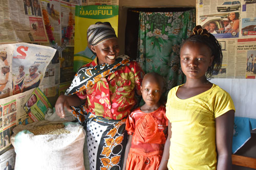 Valeria and her daughters and part of their bountiful maize harvest from ‘ngamia’ seed. B. Wawa/CIMMYT