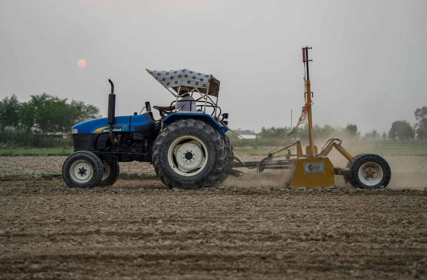 Farmer Krishna Chandra Yadav laser levels land for rice planting in Sirkohiya, Bardiya. Laser leveling is one of many climate-friendly tools that conserves water and helps farmers plant their crops more precisely and efficiently. Photo: P.Lowe/CIMMYT