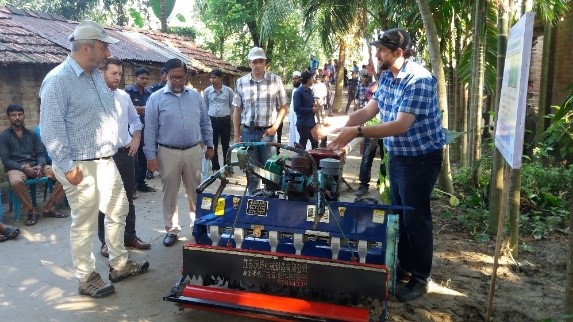 Timothy Krupnik (right) explains the use and benefits of the Power Tiller Operated Seeder to USAID Deputy Administrator Gary Lindon (far left). Photo: Md. Aktarul Islam/CIMMYT-Bangladesh