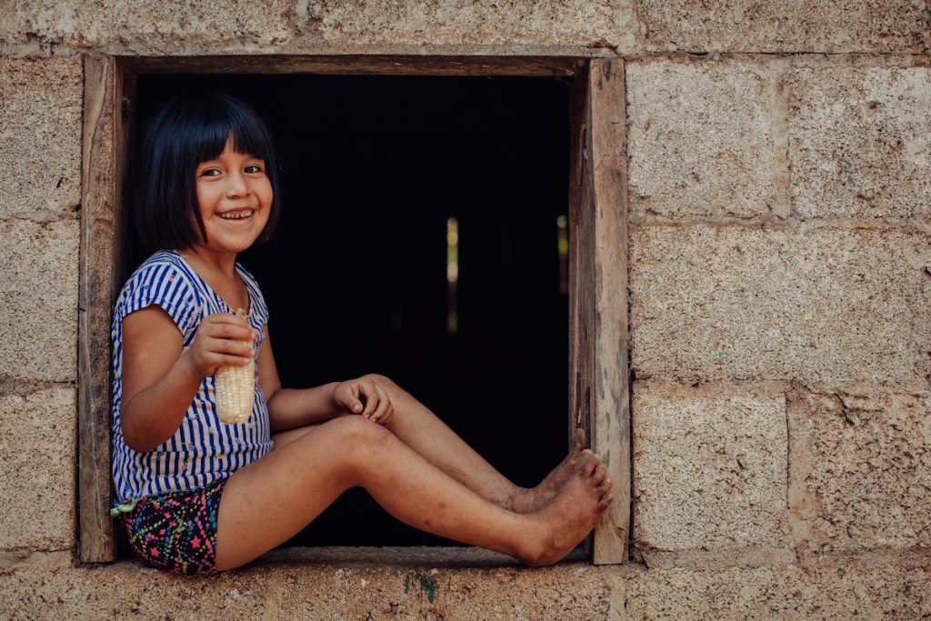 Rómulo González’s daughter holds a corncob. (Photo: Sarah Caroline Mueller)