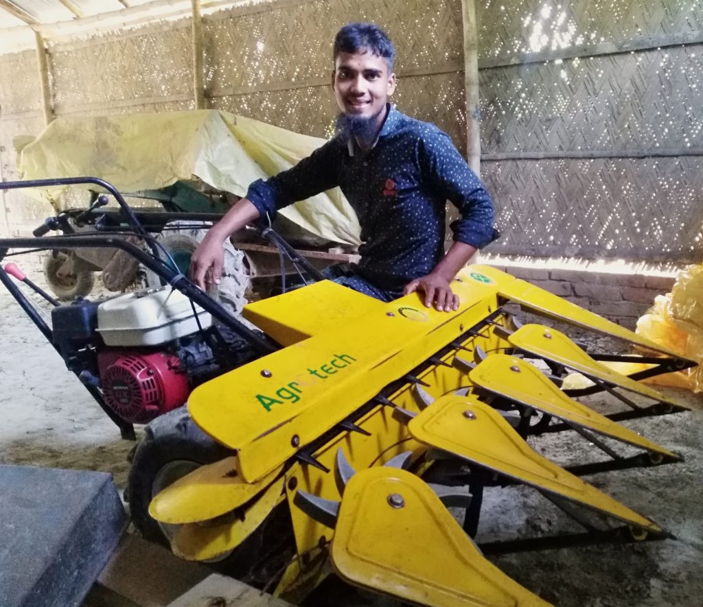 Bangladesh farmer Raju Sarder sits on his recently acquired reaper. (Photo: CIMMYT/Md. Ikram Hossain)